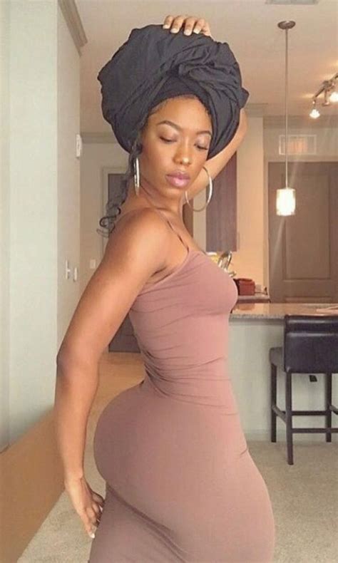 The Pregnant Woman Is Wearing A Dress And Head Wrap Standing In Front