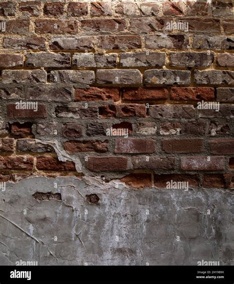 Weathered And Decaying Brick Wall With Multiple Layers Of Concrete And