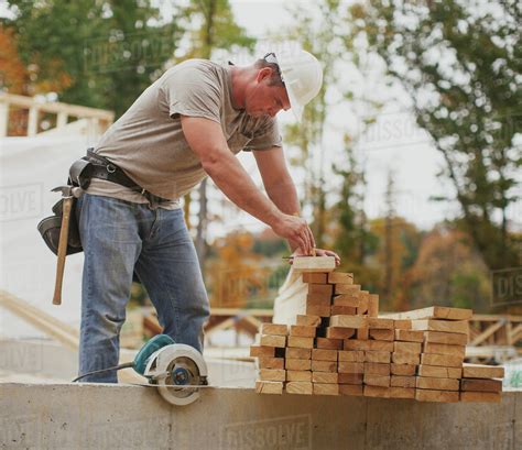 Caucasian Construction Worker Marking Wood Planks Stock Photo Dissolve