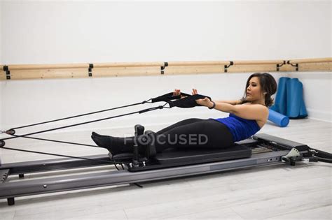 Mid Adult Woman Exercising On Reformer In Gym — Good Shape Hispanic