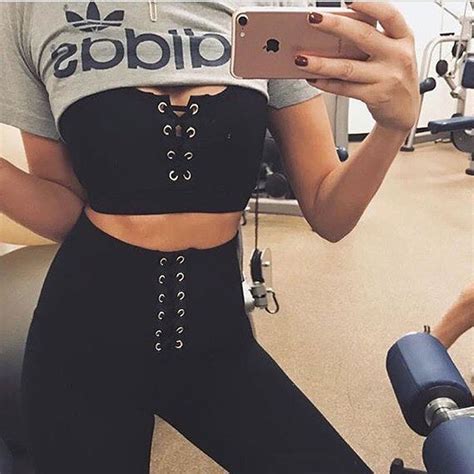 A Woman Taking A Selfie With Her Cell Phone In The Gym While Wearing