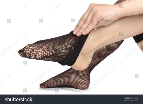 Woman Feet Dressing Fishnet Tights Over White Background Stock Photo