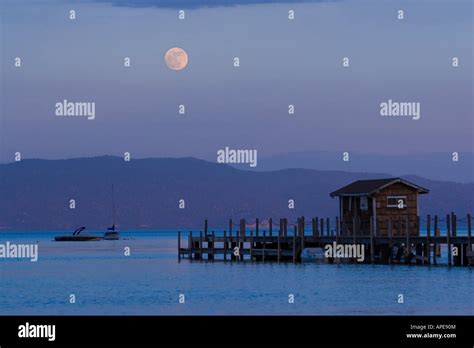 The Full Moon Rising Over Lake Tahoe California And A Pier Stock Photo