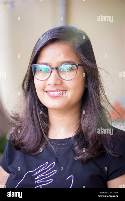 a vertical shot of a beautiful indian woman wearing glasses while looking into the camera stock