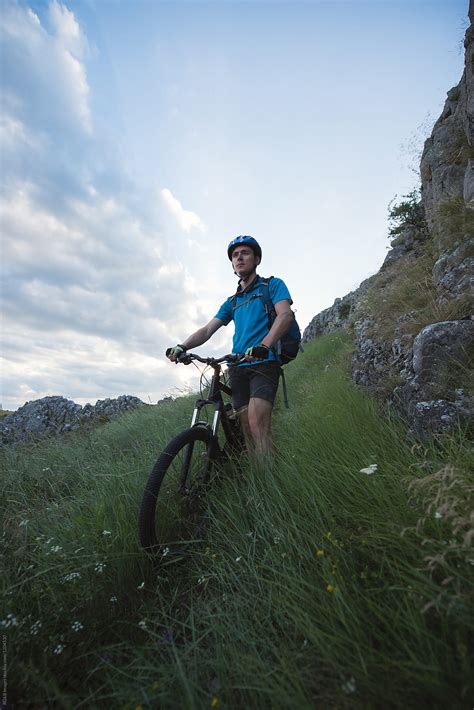 Cyclist Standing Next To His Mountain Bike On The Meadow By Stocksy Contributor Ibex Media