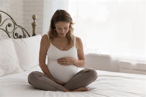 Pregnant Woman Sit On Bed Touch Belly Feeling Unconditional Love Stock