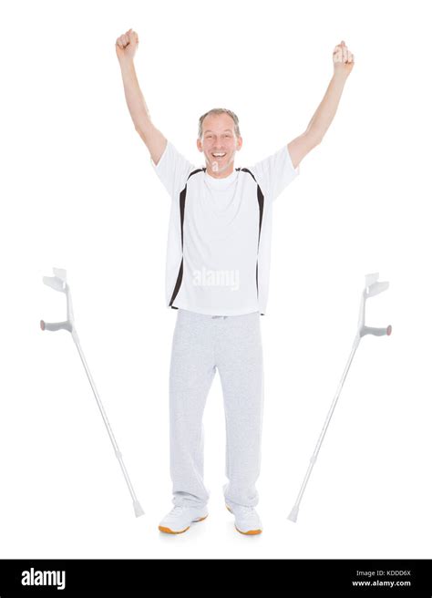 Excited Mature Man Leaving Crutches Over White Background Stock Photo