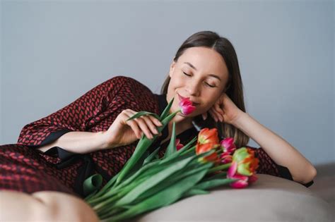 Glückliche frau genießt einen strauß tulpen hausfrau genießt einen blumenstrauß während sie