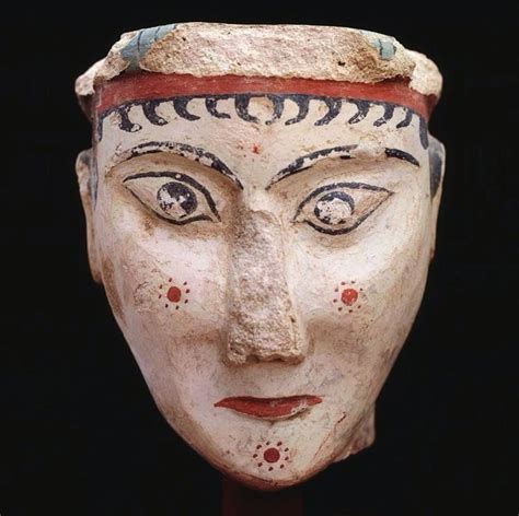 An Ancient Mask Is Displayed On A Black Background With Red And Blue