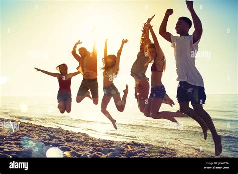 Happy Smiling Friends Jumping At The Beach Stock Photo Alamy