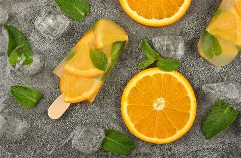 Premium Photo Orange And Mint Ice Cream Popsicles On The Table