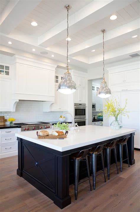 Providing a neutral backdrop, white kitchen cabinets can be left alone or dressed up with colorful art when using the duo in a kitchen with white cabinets, keep the look from becoming theatrical by practicing restraint. Black Center Island with Gray Wash Wood Floors - Transitional - Kitchen