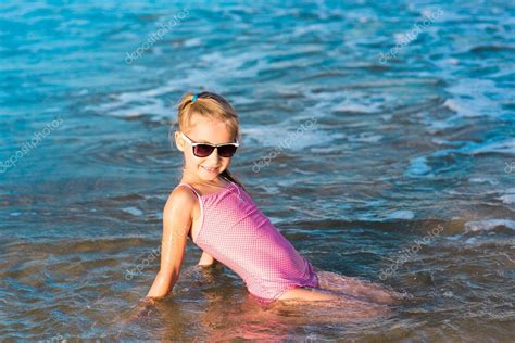 adorable niña jugando en el mar en la playa Foto de stock Len ik