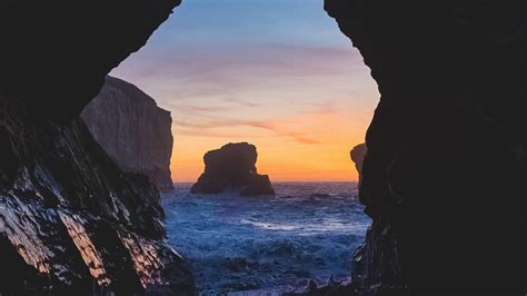 Download Wallpaper 2560x1440 Cave Rocks Sea Sunset Widescreen 169
