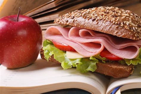 School Lunch A Ham Sandwich And An Apple On Open Notebook Stock Photo