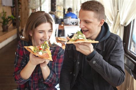 Couple Sits In A Pizzeria And Eats Pizza A Guy And A Girl Dine Fast