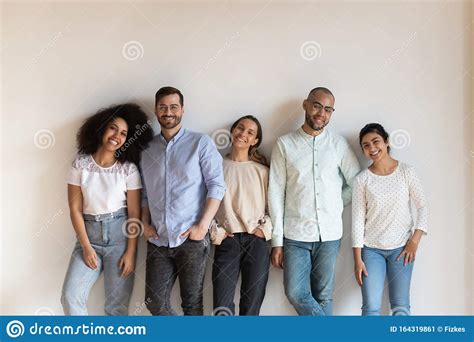 Smiling Mixed Race Young Friendly People Standing Near White Wall
