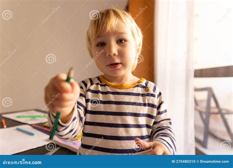 Cute Little Blonde Boy Holds Out A Colored Pencil Stock Photo Image