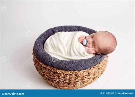 Newborn Baby Boy Sleeping Peacefully In Basket Dressed In Knitted