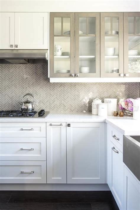 Under white shaker cabinets, a stainless steel vent hood is mounted against Saltillo imports ...