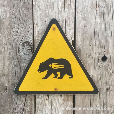 A Grizzly Bear Warning Sign In Yellow On Black Charming Bear That Has