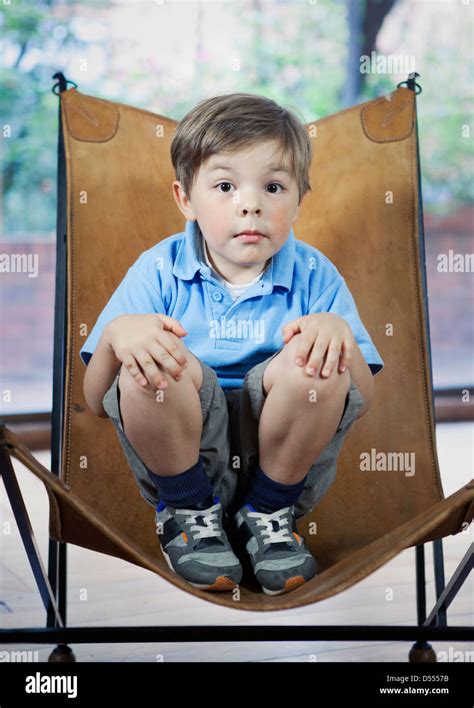 Boy Crouching In Camp Chair Stock Photo Alamy