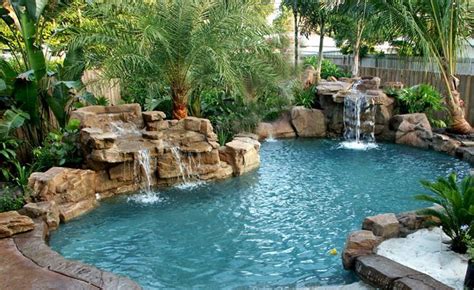 An Outdoor Swimming Pool With Waterfall And Palm Trees