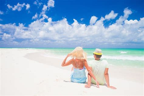 Beach Couple Sitting On White Sand Beach On Romantic Travel Honeymoon