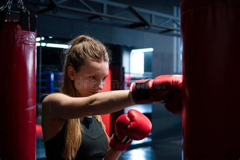 blonde caucasian fighter girl punching actively practicing in red boxing gloves stock image