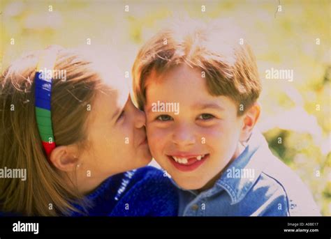 Young Girl Kissing A Boy On The Cheek Stock Photo Alamy