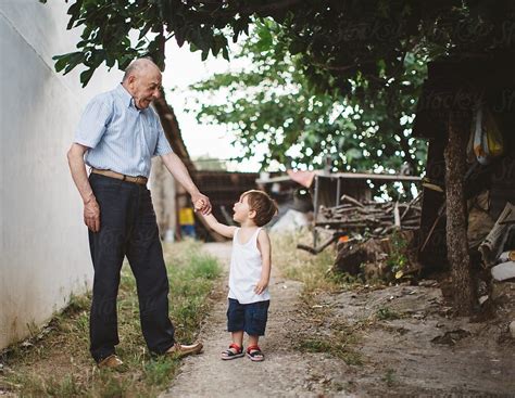 grandfather talking to his grandson outdoor by stocksy contributor nasos zovoilis