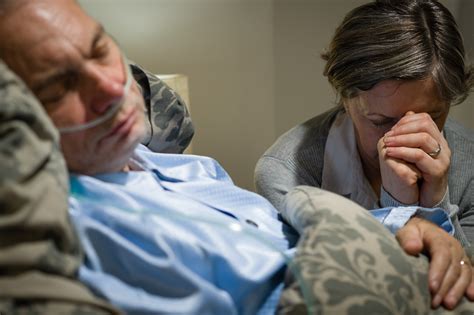 Old Wife Praying For Terminally Ill Husband Lying In Coma Royalty Free