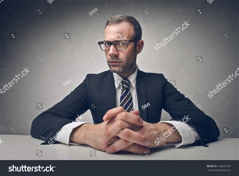 Serious Businessman Sitting At His Desk Stock Photo 128647328