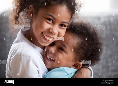 Happy African American Siblings Embracing Sitting Together Stock Photo