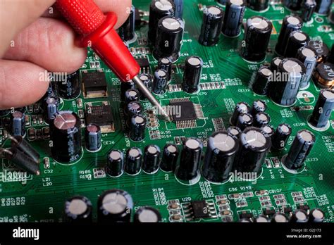 Electronics Repair Service Close Up With Red Probe And Capacitors On