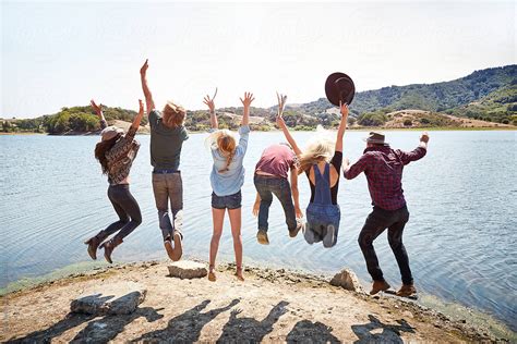 Group Of Friends Jumping In The Air At Lake In Nature By Stocksy