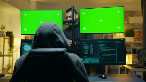 Team Of Hackers Using Computer With Green Screen Mockup To Steal Secret