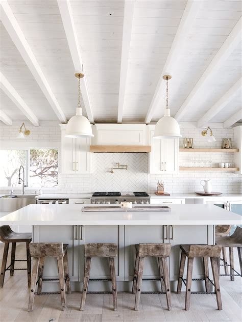 A combination of white painted cabinetry and rustic hickory cabinets create an earthy and bright kitchen. A Coastal White Kitchen | White coastal kitchen, Kitchen ...