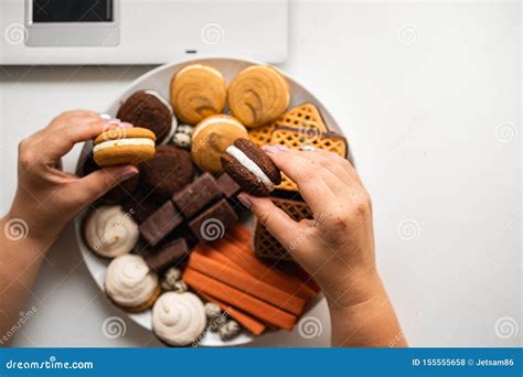 Mujer Snacking Con Los Dulces Y La Comida Basura Foto De Archivo