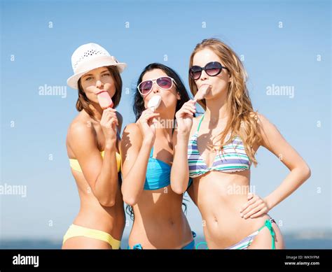 Summer Holidays And Vacation Girls In Bikinis Eating Ice Cream On The