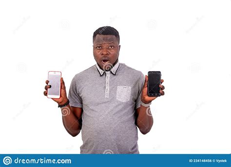 Handsome Surprised Young Man Holding Two Mobile Phones Stock Photo