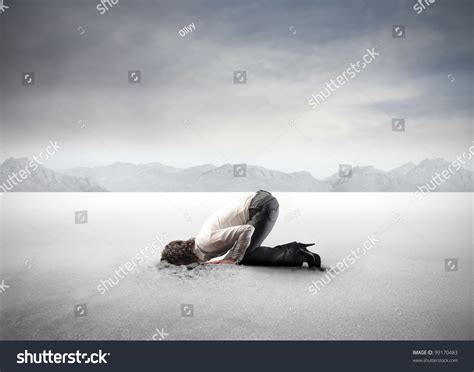 Young Woman Burying Her Head In The Sand Stock Photo 99170483