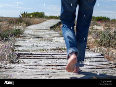 A Woman Walks Barefoot On A Wooden Gangway In A Desert Island On A Sunny Day Stock Photo Alamy