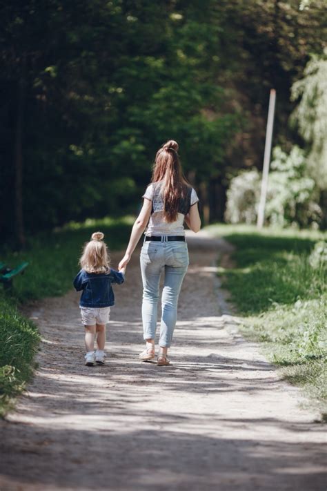 Mother And Daughter Walking On A Dirt Road Photo Free