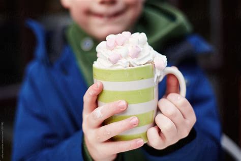 Child Holding A Mug Of Hot Chocolate With Cream And Marshmallows By