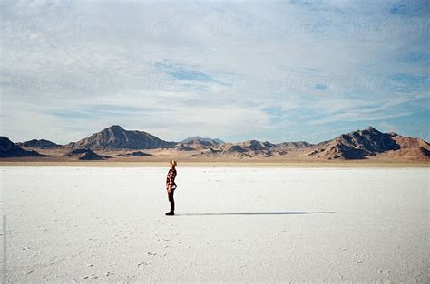 Young Male Stands In Desert With Long Shadow Del Colaborador De