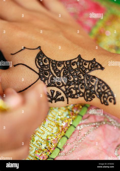Close Up Of A Woman S Hand Applying Henna Tattoo On Another Woman S