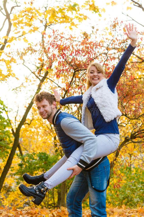 Man Giving Piggyback Ride To Woman In Park Stock Image Image Of
