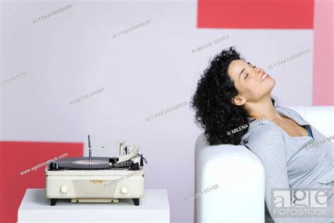 Woman Enjoying Music Listening To Old Fashioned Record Player Stock