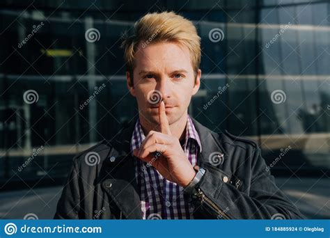 Close Up Of A Young Man With His Hands Covering His Mouth As A Sign Of